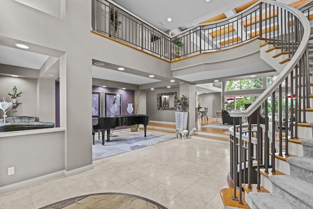 stairs featuring baseboards and a high ceiling