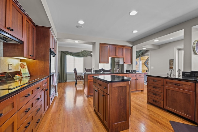 kitchen with tasteful backsplash, a center island, light wood finished floors, and recessed lighting