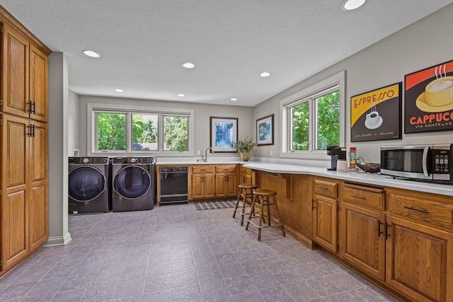clothes washing area featuring a sink, independent washer and dryer, recessed lighting, and plenty of natural light