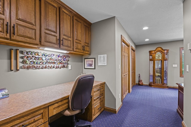 home office featuring baseboards, built in desk, dark carpet, a textured ceiling, and recessed lighting
