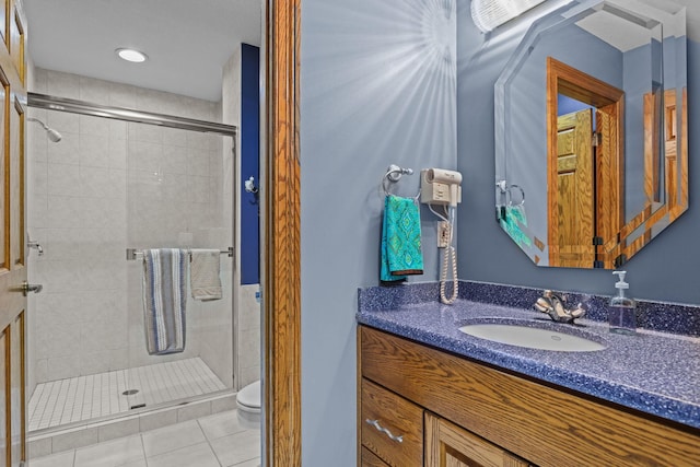 full bath featuring toilet, tile patterned floors, vanity, and a stall shower