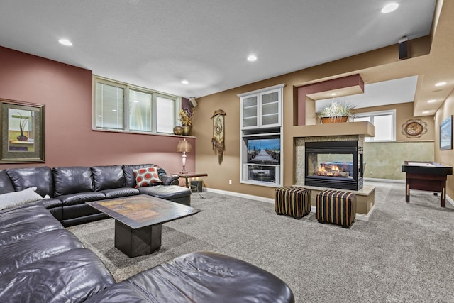 carpeted living room featuring baseboards, recessed lighting, and a multi sided fireplace
