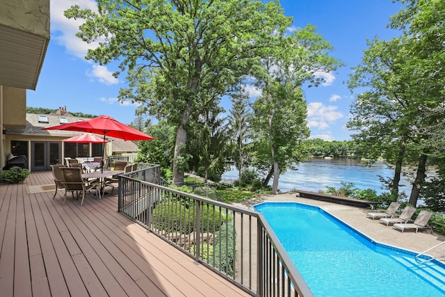 pool with french doors, outdoor dining area, and a deck with water view