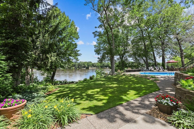view of yard featuring an outdoor pool and a water view