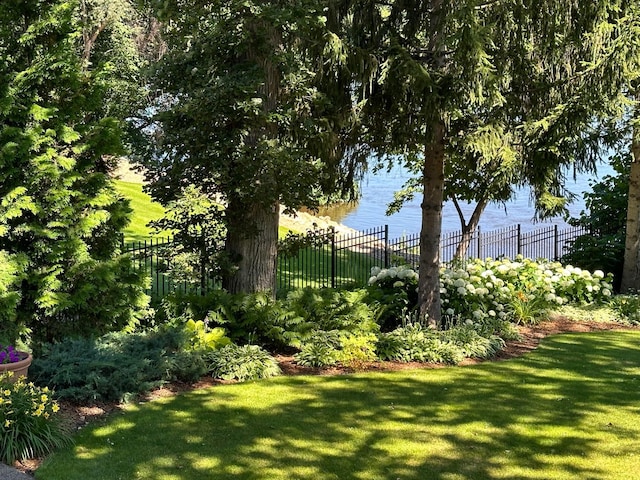 view of yard with a water view and fence