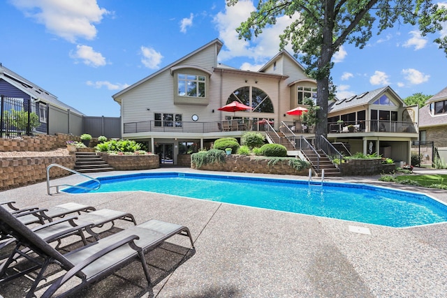 outdoor pool featuring a deck, a patio, and stairs