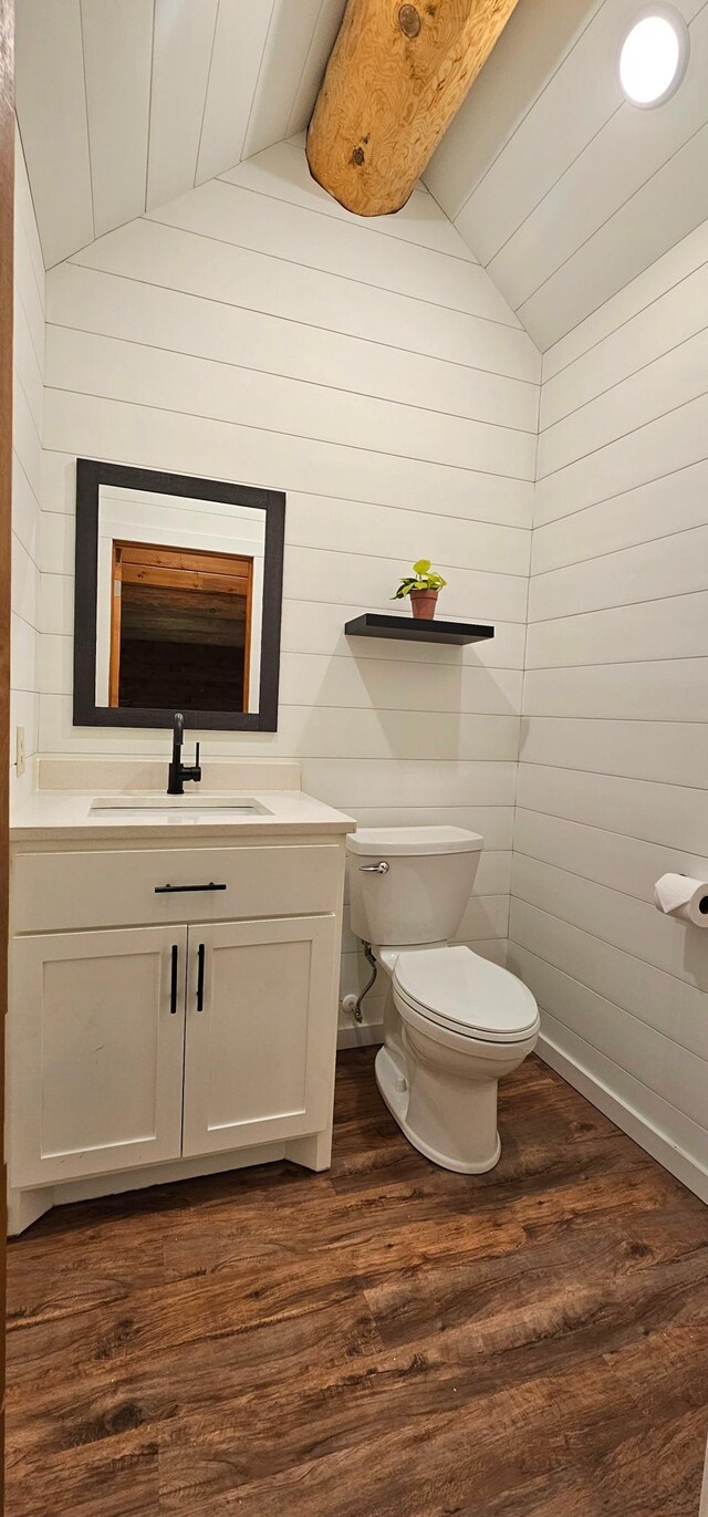 46174 County Highway 35, Vergas, MN 56587 - bathroom with vaulted ceiling, wood finished floors, toilet, wooden walls, and vanity