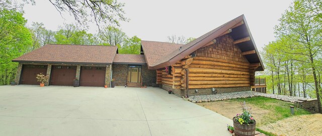 46174 County Highway 35, Vergas, MN 56587 - view of front of home featuring log exterior, driveway, a shingled roof, and an attached garage