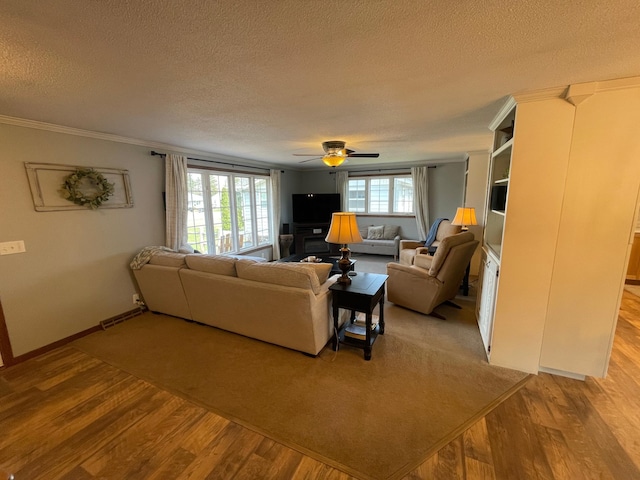 1211 Diagonal Rd, Worthington, MN 56187 - living area with a textured ceiling, wood finished floors, a ceiling fan, baseboards, and crown molding
