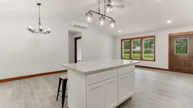 24888 65th Ave, Sigel Twp, WI 54727 - kitchen with a wall mounted AC, light wood finished floors, white cabinetry, vaulted ceiling, and a kitchen island