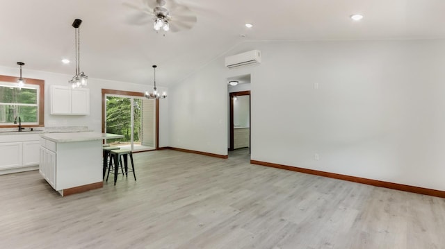 24888 65th Ave, Sigel Twp, WI 54727 - kitchen with a wall mounted air conditioner, ceiling fan, a center island, white cabinets, and a breakfast bar area