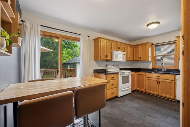 3011 Brunswick Ave S, Saint Louis Park, MN 55416 - kitchen featuring white appliances, a sink, dark countertops, and dark stone finish flooring