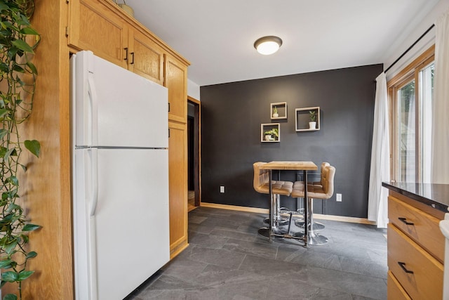 3011 Brunswick Ave S, Saint Louis Park, MN 55416 - kitchen with freestanding refrigerator, baseboards, and dark stone finish flooring