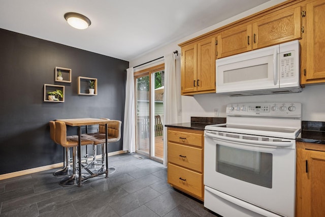 3011 Brunswick Ave S, Saint Louis Park, MN 55416 - kitchen with white appliances, dark countertops, brown cabinetry, and baseboards