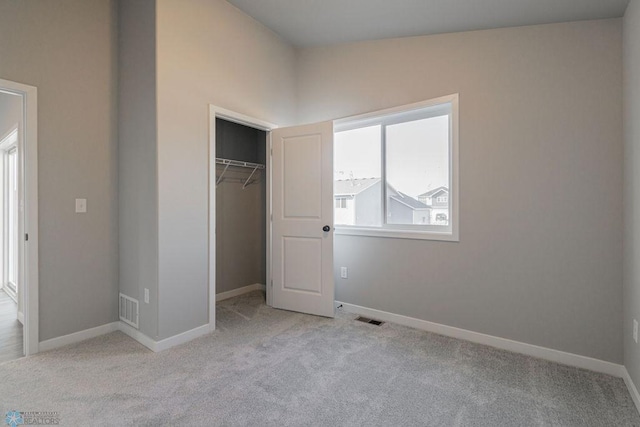 unfurnished bedroom featuring visible vents, baseboards, a closet, and carpet
