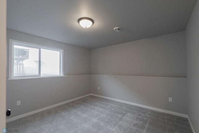 spare room featuring baseboards and carpet