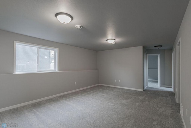 carpeted empty room featuring baseboards