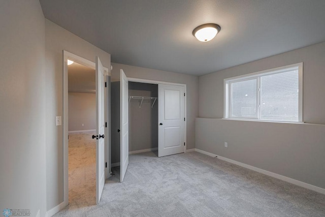 unfurnished bedroom with a closet, baseboards, and carpet flooring