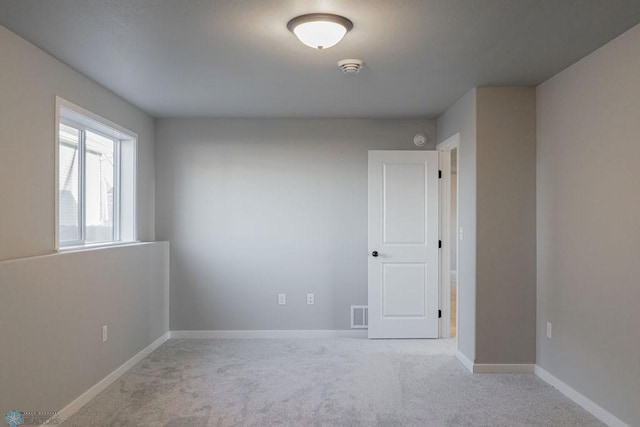 spare room featuring visible vents, baseboards, and carpet
