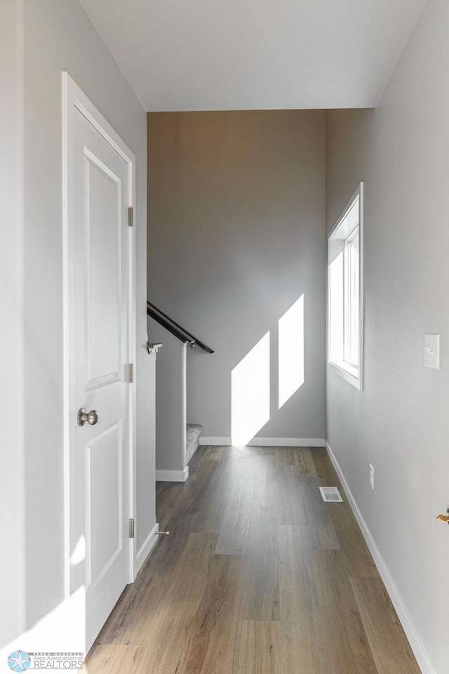 interior space with wood finished floors, baseboards, and stairway