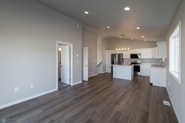 kitchen with a center island, a sink, open floor plan, recessed lighting, and stainless steel appliances