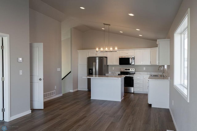 kitchen with white cabinetry, a kitchen island, visible vents, stainless steel appliances, and a sink
