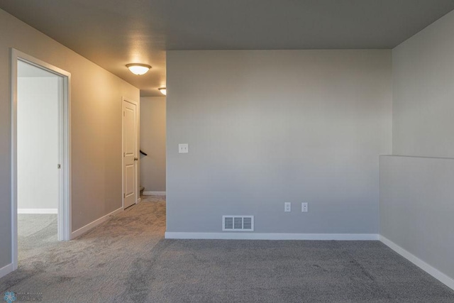 unfurnished room with carpet flooring, visible vents, and baseboards