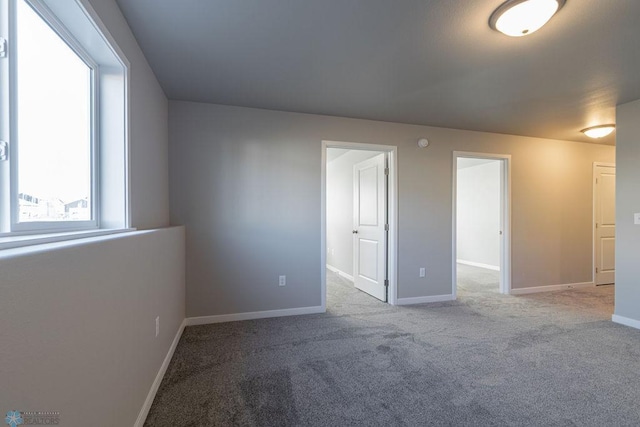 unfurnished room with baseboards and carpet flooring