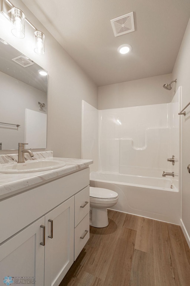 full bathroom with toilet, shower / bathtub combination, wood finished floors, and visible vents