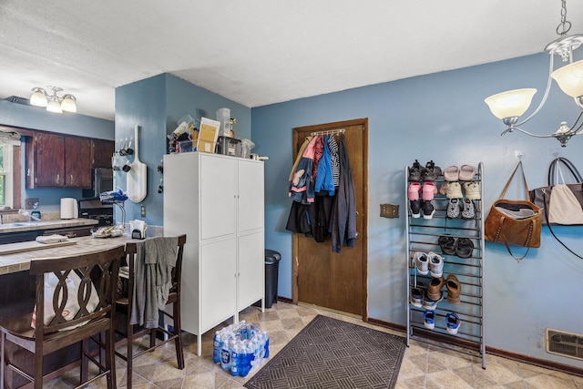 7716 Orchard Ave N, Brooklyn Park, MN 55443 - kitchen featuring a chandelier, baseboards, and stainless steel microwave