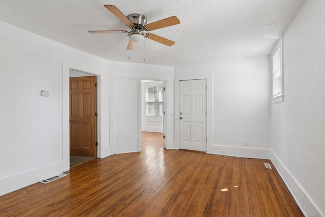 1208 University Ave NE, Minneapolis, MN 55413 - spare room with healthy amount of natural light, wood-type flooring, ceiling fan, a textured ceiling, and baseboards