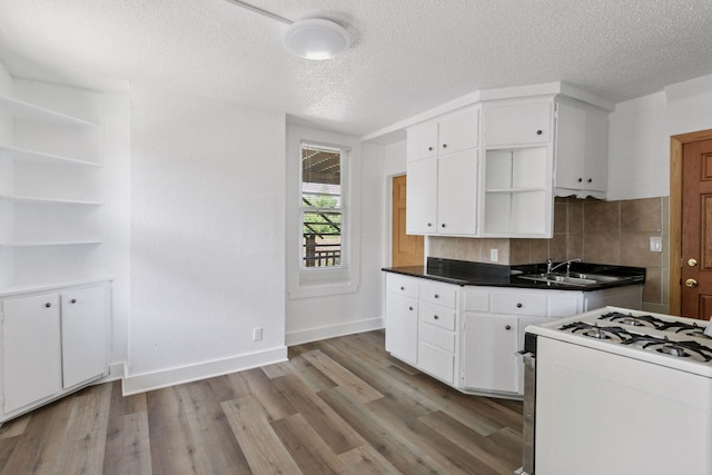 1208 University Ave NE, Minneapolis, MN 55413 - kitchen with open shelves, white range with gas stovetop, white cabinets, baseboards, and light wood finished floors