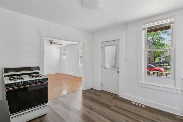 1208 University Ave NE, Minneapolis, MN 55413 - kitchen featuring range with gas stovetop, a textured ceiling, wood finished floors, baseboards, and ceiling fan