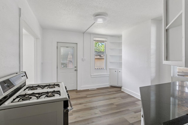 1208 University Ave NE, Minneapolis, MN 55413 - kitchen with gas range gas stove, a textured ceiling, light wood finished floors, and baseboards