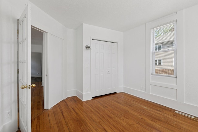 1208 University Ave NE, Minneapolis, MN 55413 - unfurnished bedroom featuring wood-type flooring, baseboards, and a closet