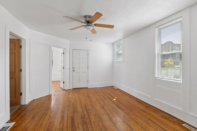 1208 University Ave NE, Minneapolis, MN 55413 - unfurnished bedroom featuring wood-type flooring, a textured ceiling, ensuite bath, and ceiling fan