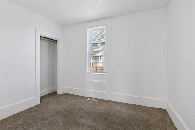 1208 University Ave NE, Minneapolis, MN 55413 - spare room featuring dark colored carpet and a textured ceiling