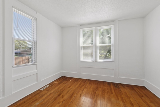 1208 University Ave NE, Minneapolis, MN 55413 - empty room with wood-type flooring, a textured ceiling, and baseboards