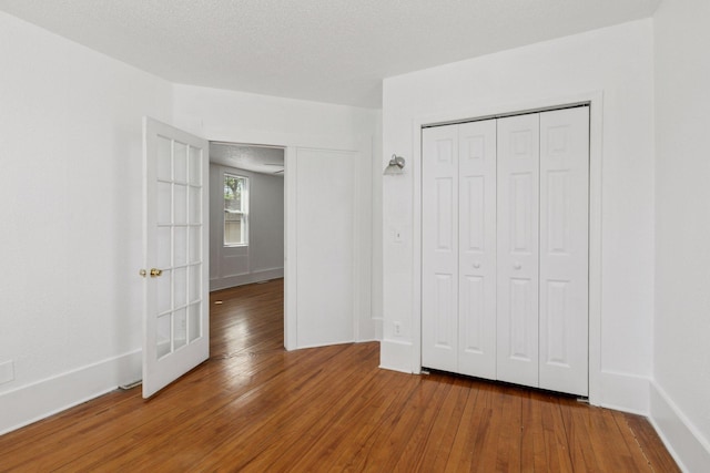 1208 University Ave NE, Minneapolis, MN 55413 - unfurnished bedroom with wood finished floors, a closet, and baseboards
