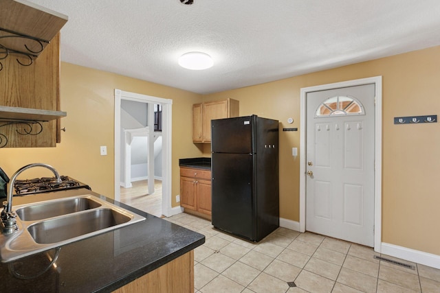 1208 University Ave NE, Minneapolis, MN 55413 - kitchen with freestanding refrigerator, a sink, dark countertops, baseboards, and a textured ceiling
