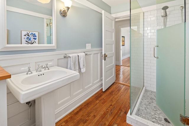 2774 Lake Of The Isles Pkwy, Minneapolis, MN 55416 - bathroom featuring tiled shower, wood-type flooring, and wainscoting