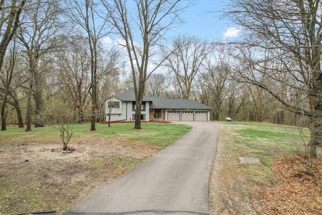 view of front of property with a front yard, driveway, a garage, and a shingled roof