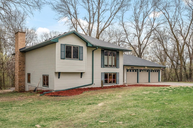 view of front facade with driveway, a chimney, a front lawn, and a garage