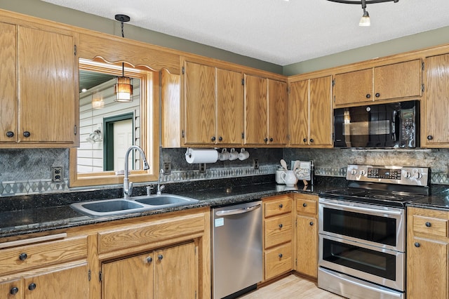 kitchen with backsplash, a sink, appliances with stainless steel finishes, and light wood-type flooring