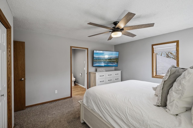 carpeted bedroom featuring a textured ceiling, ceiling fan, ensuite bathroom, and baseboards