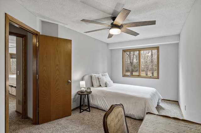 bedroom featuring a textured ceiling, carpet flooring, and ceiling fan