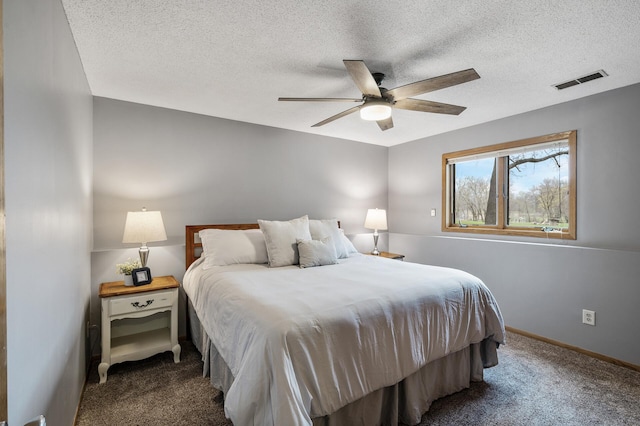bedroom with dark carpet, a textured ceiling, and visible vents