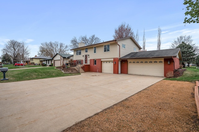 bi-level home featuring a chimney, a front yard, brick siding, concrete driveway, and an attached garage