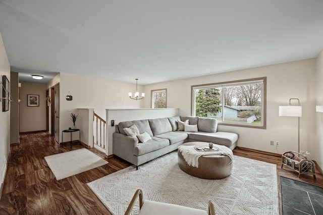 living room featuring baseboards, wood finished floors, and a notable chandelier
