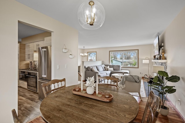 dining space with wood finished floors and a chandelier